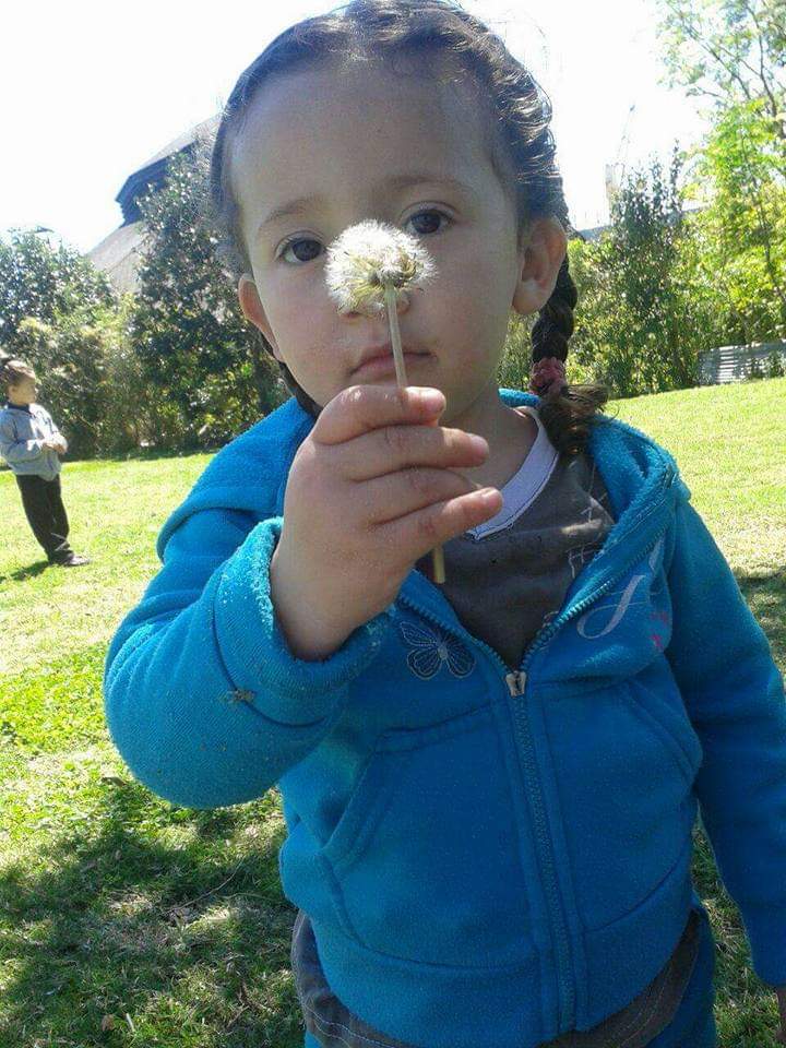 Sophie Avril de niña soplando un diente de león